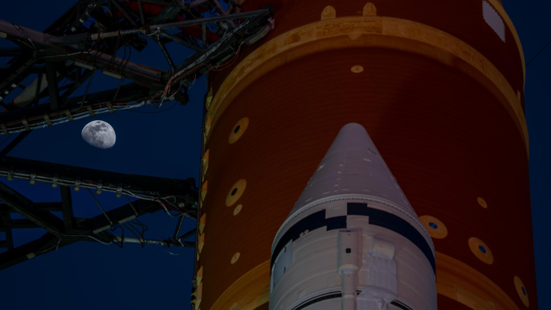 The Moon is seen shining over the SLS (Space Launch System) and Orion spacecraft, atop the mobile launcher on January 28, 2026. The rocket is currently at Launch Pad 39B at NASA’s Kennedy Space Center in Florida, as teams are preparing for a wet dress rehearsal to practice timelines and procedures for the launch of Artemis II.